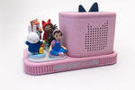 May include: A pink audio player with a speaker and a decorative base. The base holds several figurines, including a rabbit, a tiger, and a girl. The player has a cat-shaped speaker design and the text "LIYA'S TONIEBOX".